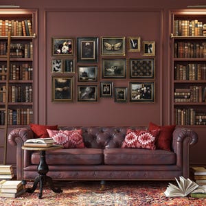 May include: A cozy library scene with a tufted leather sofa, a small round table, and a patterned rug. The walls are adorned with framed artwork and flanked by bookshelves filled with books. A wooden ladder leans against one of the shelves.