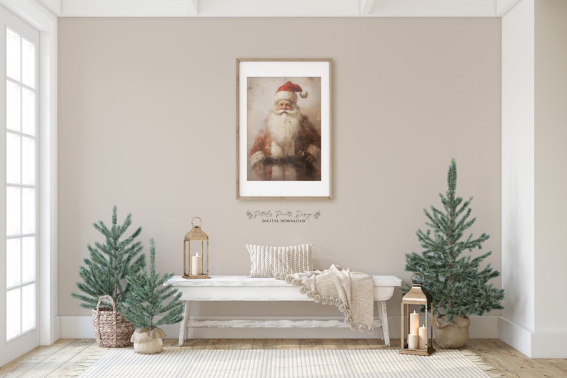 May include: A framed painting of Santa Claus with a red hat and white beard. The painting is hanging on a wall with a white bench in front of it. There are two small artificial Christmas trees on either side of the bench.