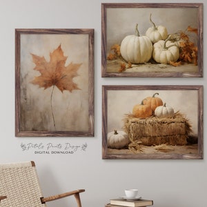 May include: Set of three digital prints featuring fall-themed imagery. The first print shows a single brown maple leaf on a white background. The second print shows a group of white pumpkins on a brown background. The third print shows three pumpkins, two orange and one white, on a bale of hay.