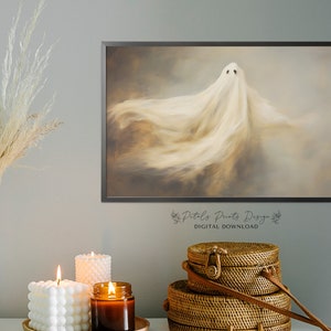 May include: A digital download of a printable art print featuring a white ghost with a soft, ethereal glow against a brown and grey background. The print is framed in a black frame and has the text "Petals Prints Designs" and "DIGITAL DOWNLOAD" at the bottom.