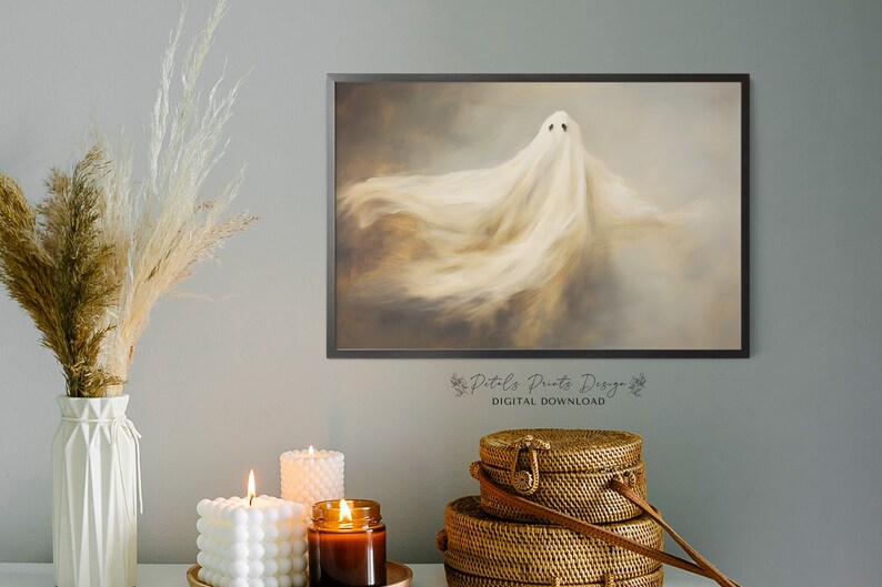 May include: A digital download of a printable art print featuring a white ghost with a soft, ethereal glow against a brown and grey background. The print is framed in a black frame and has the text "Petals Prints Designs" and "DIGITAL DOWNLOAD" at the bottom.