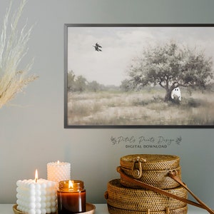 May include: A digital download of a watercolor painting featuring a white ghost hiding behind a tree in a field. Two black birds fly overhead. The painting has a soft, muted color palette.