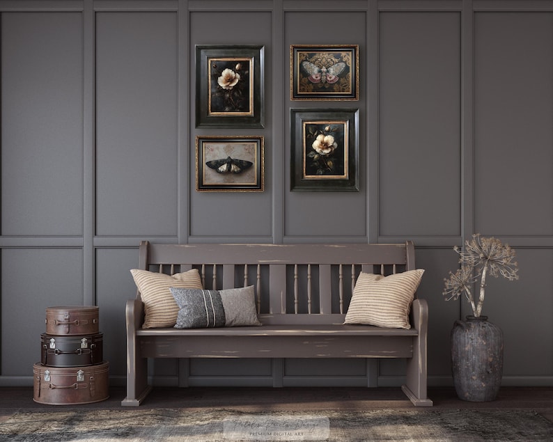 May include: A decorative wall arrangement featuring four framed botanical and insect prints above a wooden bench with pillows. A stack of vintage suitcases and a vase with dried flowers complete the scene. The color palette is muted with shades of gray and brown.