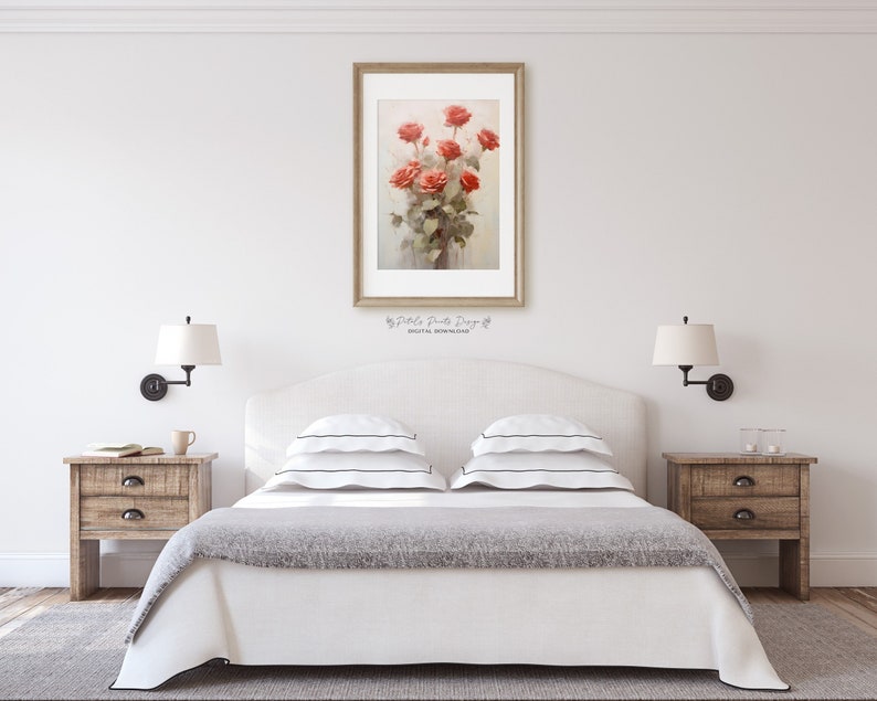 May include: A white bed with a gray blanket and two white pillows with black stripes. There are two wooden nightstands with lamps on either side of the bed. A framed print of a bouquet of red roses is hanging on the wall above the headboard.