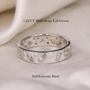 Könnte beinhalten: Ein silberner Bandring mit einem Voll-Eternity-Band-Design. Der Ring ist mit mehreren kleinen Diamanten in verschiedenen Formen besetzt, darunter runde, Birnen- und Baguette-Diamanten. Der Ring ist 1.22 CT Multi Shape Lab Grown.