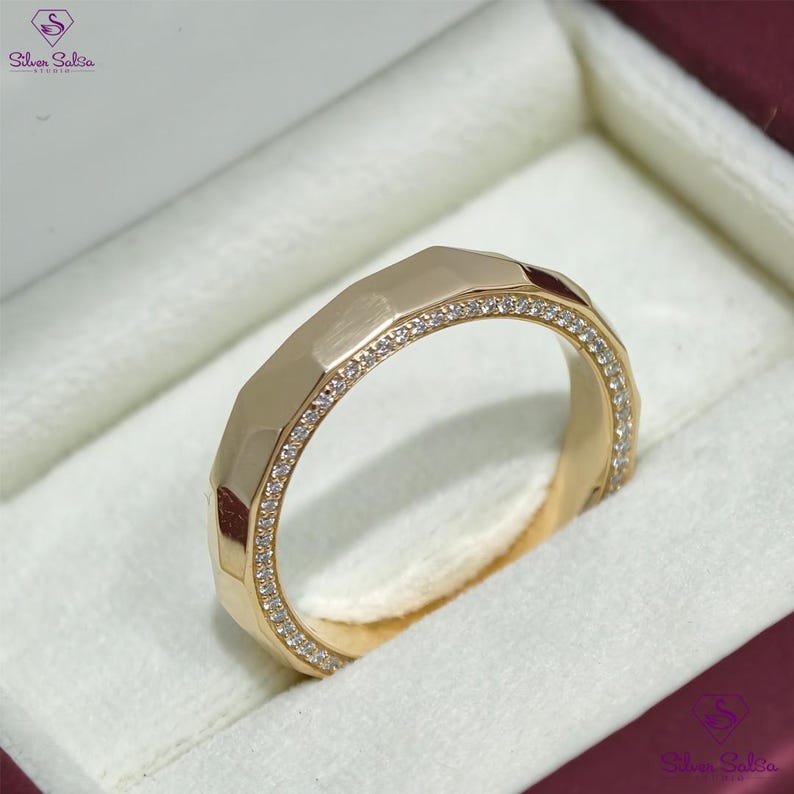May include: A gold ring with a geometric design and a row of small, clear gemstones. The ring is set in a white jewelry box, with the Silver Salsa logo visible in the corner.