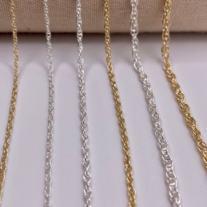 May include: Five different chain styles in silver and gold. The chains are arranged vertically and are all the same length.