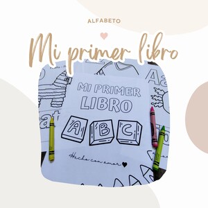 Könnte beinhalten: Ein Schwarzweiß-Malbuch mit dem Titel "Mi primer libro" und dem Text "Hecho con amor". Das Buch zeigt Bilder von Buchstaben, einer Piñata und einer Sonne.