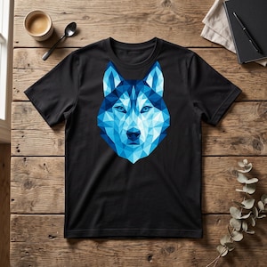 以下が含まれることがあります： 黒の半袖Tシャツで、中央にオオカミの頭の大きなグラフィックが描かれています。このグラフィックは、明るいシアンから深いネイビーまで、さまざまな色合いの青い幾何学模様で構成されており、暗い鼻と尖った耳が特徴です。