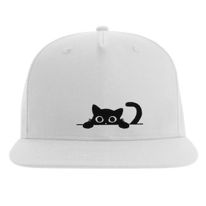 Könnte beinhalten: Weiße Baseballkappe mit einer schwarzen Katze, die über den Rand schaut. Die Katze hat große Augen und einen Schwanz, der sich um den Rand schlingt.
