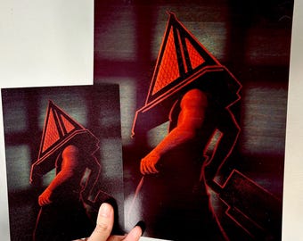 May include: Two rectangular art prints featuring a dark, stylized illustration of a figure with a large, triangular, red-glowing head. The figure is depicted in silhouette with a muscular arm and a large, heavy blade held at the side.