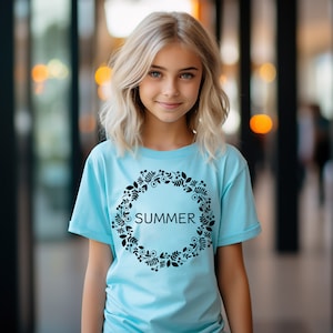 May include: A light blue t-shirt with a black floral wreath design and the word "SUMMER" in the center.