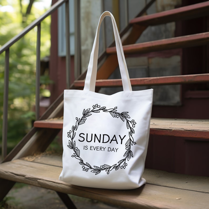 May include: White canvas tote bag with black floral wreath and the text "SUNDAY IS EVERY DAY".