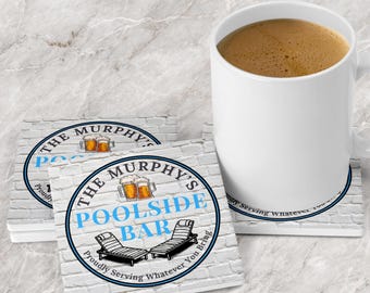May include: Square white coasters with a brick pattern and a circular logo featuring two beer mugs, two lounge chairs, and the text THE MURPHY'S POOLSIDE BAR PROUDLY SERVING WHATEVER YOU BRING, accompanied by a white ceramic mug filled with coffee.