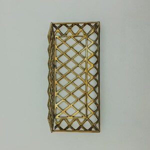 May include: A gold metal tray with a diamond-shaped wire mesh design. The tray is empty and has a rectangular shape.