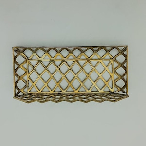 May include: A gold metal tray with a diamond-shaped grid pattern. The tray is empty and has a slightly raised edge.