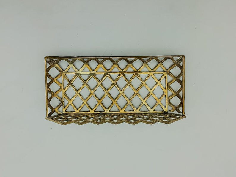 May include: A gold metal tray with a diamond-shaped grid pattern. The tray is empty and has a slightly raised edge.
