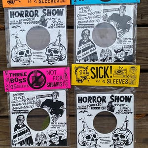 May include: A collection of vinyl record sleeves with a horror theme. The sleeves feature black and white illustrations of skulls, monsters, and text like "HORROR SHOW" and "SICK! SLEEVES". The sleeves are packaged in clear plastic.