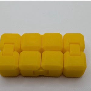 May include: A bright yellow fidget toy composed of eight connected, rectangular blocks. Each block is connected to the next by a small, hinged connector, allowing for flexible movement and manipulation. The toy is designed for tactile engagement.