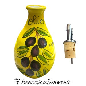 May include: Yellow ceramic olive oil bottle with a hand-painted design of olives and leaves. The bottle has the word "Olio" written on it. The bottle comes with a cork stopper and a metal pour spout.