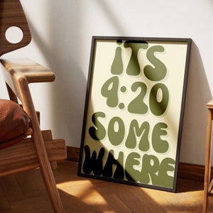 May include: A framed print with a yellow background and green text that reads "ITS 9:20 SOMEWHERE".
