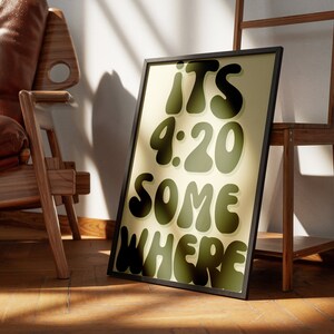 May include: A framed print with a yellow background and black text that reads "ITS 4:20 SOMEWHERE". The text is in a retro, bubbly font.