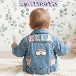 Pode incluir: Uma caneca de cerâmica branca com uma alça preta e o texto "But First, Coffee" em preto, com uma fonte manuscrita. A caneca está sobre uma superfície branca.