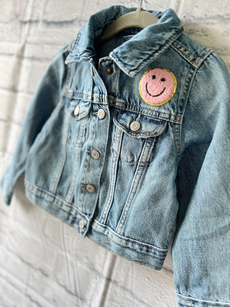 a denim jacket with a smiley face on it