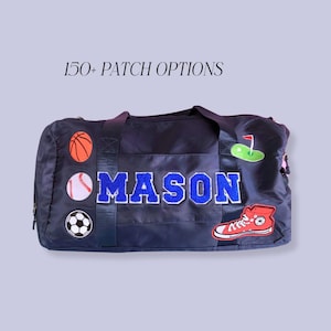 May include: Navy blue duffel bag with the name "MASON" in blue and white patches. Sports-themed patches include a basketball, baseball, soccer ball, golf flag, and a red sneaker. The text "150+ PATCH OPTIONS" is above the bag.