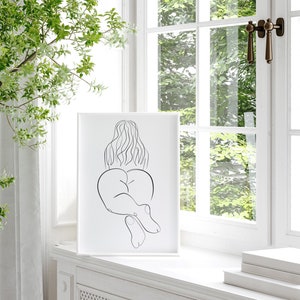 May include: A black and white line drawing of a person sitting with their back to the viewer. The drawing is on a white background and is framed in a white frame.