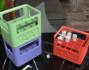 May include: Three plastic crates, one stacked on top of the other. The top crate is green, the middle crate is blue, and the bottom crate is red. The crates have a grid pattern and the word "ZAVA" printed on the front.