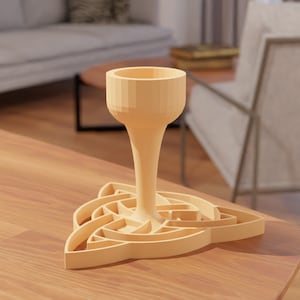Puede incluir: Un cáliz de madera con una base de diseño de nudo celta. El cáliz es de color marrón claro y tiene una forma redonda y lisa.