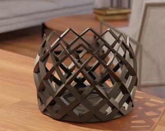 Puede incluir: Un cuenco decorativo de metal negro con un diseño geométrico. El cuenco está hecho de malla de alambre y tiene una forma redonda.