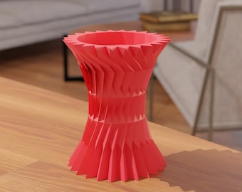 Puede incluir: Un jarrón de origami rojo con un diseño de estrella. El jarrón está hecho de papel doblado y tiene una forma geométrica única.
