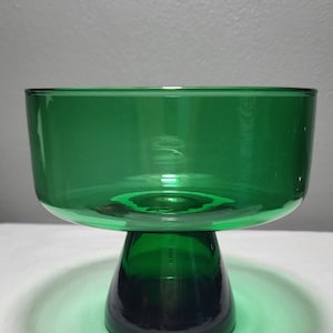 May include: A green glass pedestal bowl with a wide, round bowl and a flared, round base.