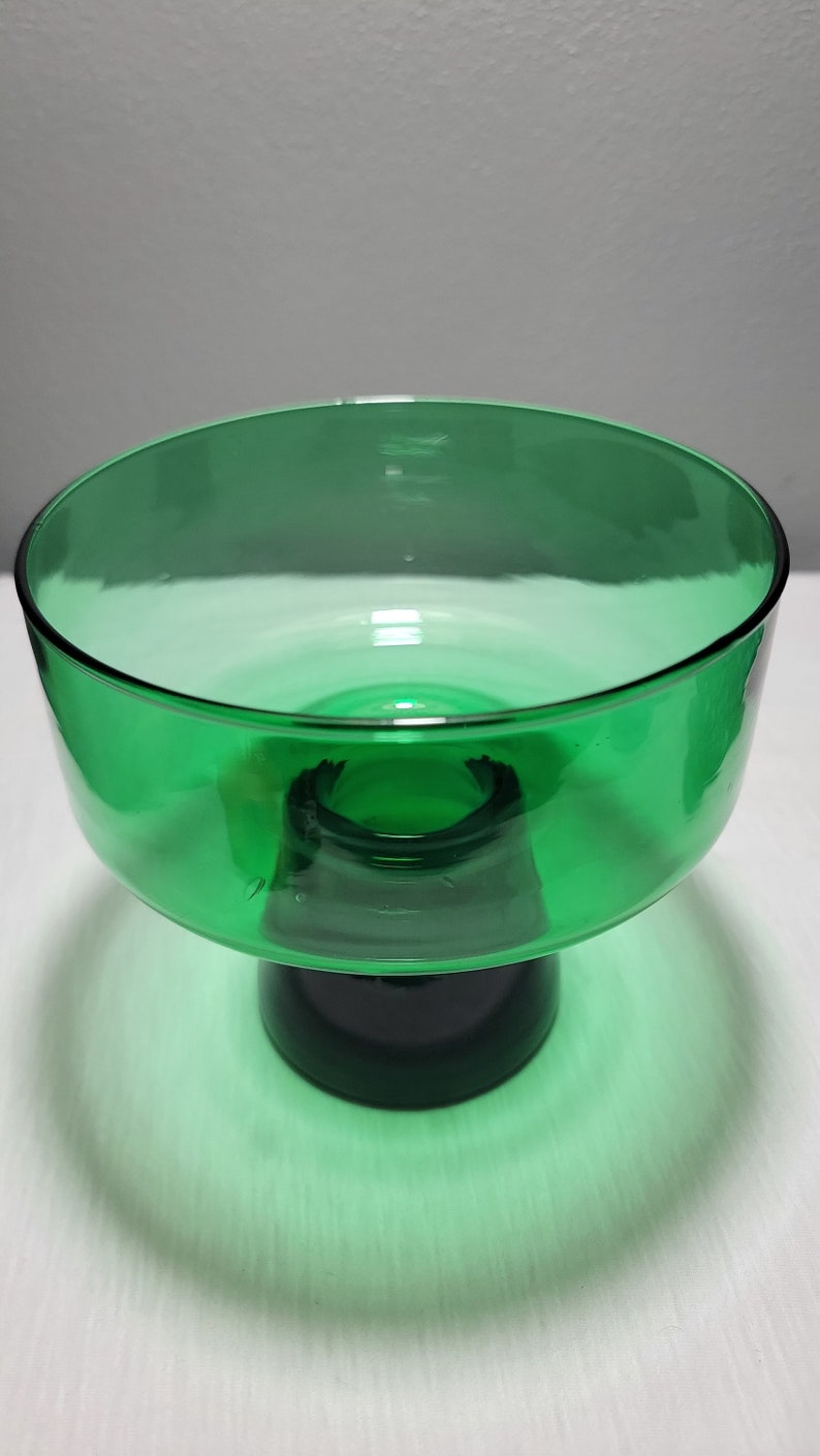 May include: A green glass pedestal bowl with a wide, shallow bowl and a thick, round base.