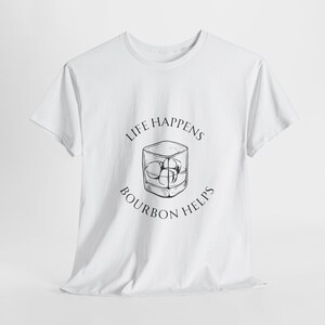Pode incluir: Camiseta branca com um gráfico preto de um copo de bourbon com cubos de gelo e o texto "Life Happens Bourbon Helps."