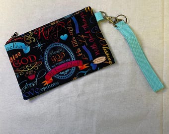 May include: Black zippered pouch with a wrist strap. The pouch is covered in colorful script and phrases, including "Praise God" and "With God All Things Are Possible." The wrist strap is light blue with white polka dots.