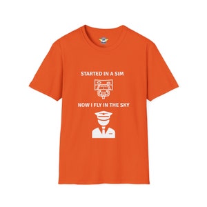 orange colored shirt with the text Started in a Sim Now I Fly in the Sky Shirt has a picture of a computer monitor with a yoke in front of it and an airline captain pilot