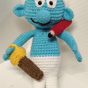 Puffo pratico all&#39;uncinetto con cappello bianco e strumenti, industriosa creatura blu, personaggio dei cartoni animati blu, minuscole creature blu con pantaloni bianchi,