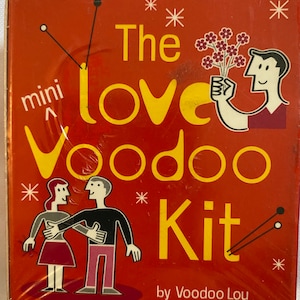 May include: A red box with the text "The Love Voodoo Kit" in yellow letters. The box has a mini voodoo doll, a couple holding hands, and a person holding flowers. The text "by Voodoo Lou" is at the bottom of the box.