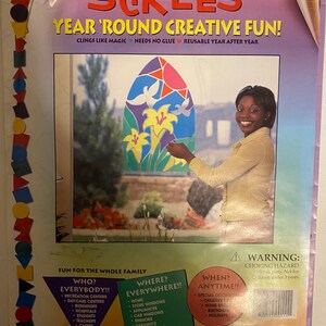 May include: A package of reusable, colorful, window clings featuring a stained glass design of lilies and doves. The package includes the text "Stik-Ees Year 'Round Creative Fun!" and "Sunlight Lilies Code 111".