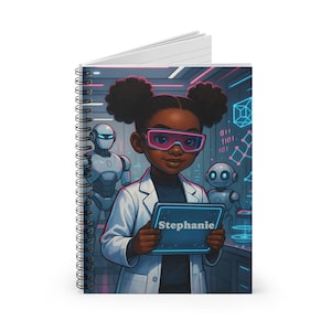 May include: Spiral-bound notebook featuring a cartoon illustration of a young girl in a lab coat and pink glasses, holding a tablet with the name "Stephanie." The background includes robots and binary code, suggesting a science or technology theme.