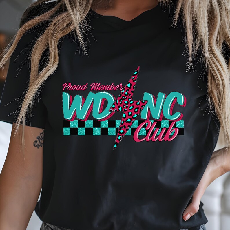 May include: Black t-shirt with a graphic design. The design features the text "Proud Member WD NC Club" in teal and pink, with a lightning bolt and checkered pattern.