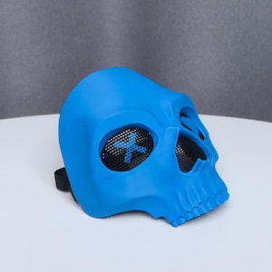 May include: A bright blue skull mask with mesh eye coverings and a black strap. The mask is made of a smooth material and has a detailed skull design. The eye coverings have a blue cross design.