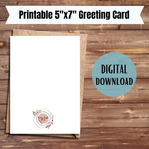 May include: A blank white greeting card with a floral design on the bottom right corner. The card is 5 inches by 7 inches and is on a brown wooden background. The text "Printable 5"x7" Greeting Card" is at the top of the image. The text "DIGITAL DOWNLOAD" is in a blue circle on the right side of the image.