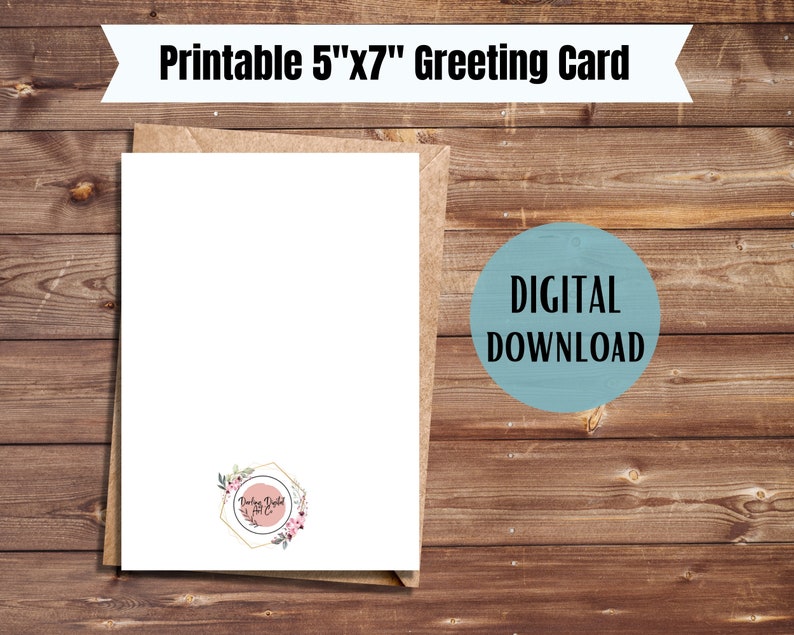 May include: A blank white greeting card with a floral design on the bottom right corner. The card is 5 inches by 7 inches and is on a brown wooden background. The text "Printable 5"x7" Greeting Card" is at the top of the image. The text "DIGITAL DOWNLOAD" is in a blue circle on the right side of the image.