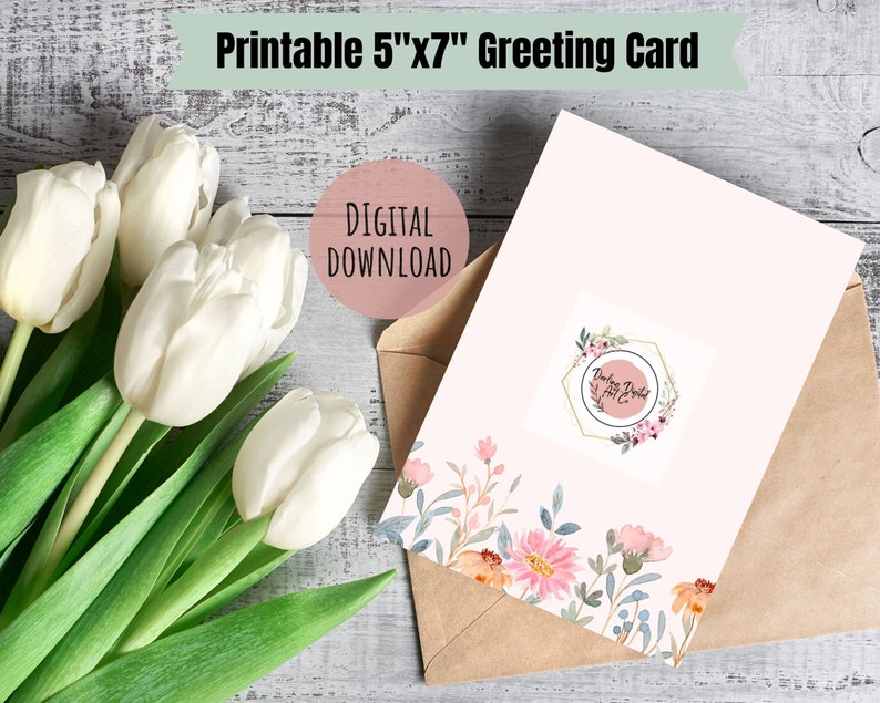 May include: Printable 5"x7" greeting card with a floral design and the text "Darling Printed" in a gold hexagon frame. The card is on a brown envelope and a bouquet of white tulips is in the background.