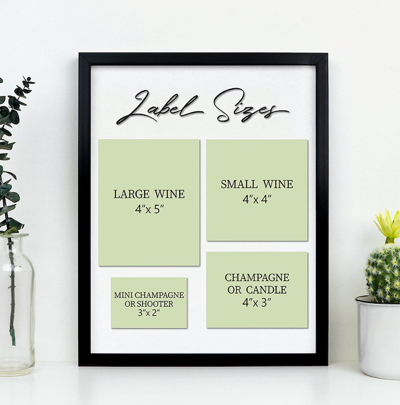 K&ouml;nnte beinhalten: Ein schwarzer Rahmen mit einer wei&szlig;en Tafel, auf der der Text "Label Sizes" in Kursivschrift steht. Die Tafel ist in vier Abschnitte unterteilt, die mit gr&uuml;nen Etiketten versehen sind, auf denen verschiedene Gr&ouml;&szlig;en f&uuml;r Wein-, Champagner- und Kerzen-Etiketten angegeben sind. Die Gr&ouml;&szlig;en sind in Zoll angegeben.