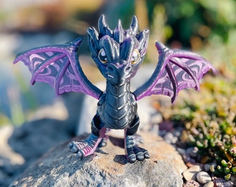 May include: A small black dragon figurine with purple wings. The dragon has a detailed, textured surface and a fierce expression.
